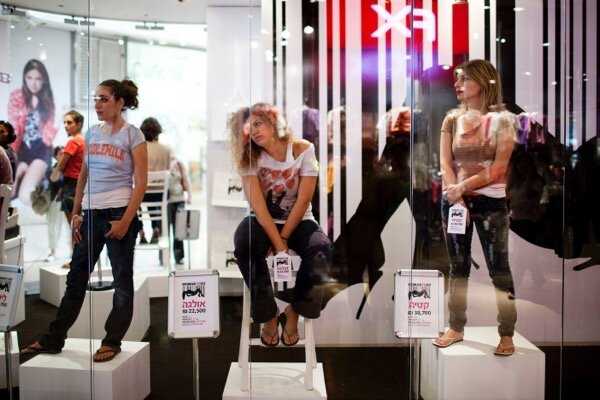 TEL AVIV, ISRAEL - OCTOBER 19: (ISRAEL OUT) Women stand in a store window at a shopping mall with price tags on their hands on October 19, 2010 in Tel Aviv, Israel. The store, opened for a day, was used to raise awareness of the trafficking of women. (Photo by Uriel Sinai/Getty Images)
